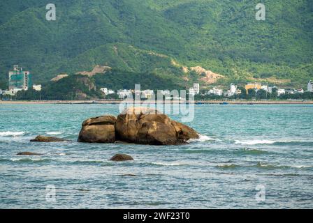 La costa del resort vietnamita di Nha Trang si rivela in uno spettacolo vibrante. la pittoresca costa rocciosa incontra il mare azzurro sotto il sole radioso e il panorama delle spiagge Foto Stock