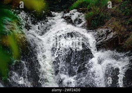 piccola cascata con acqua che scorre su pietre marroni. paesaggio naturale caratterizzato da pittoresche cascate con il suo flusso che si innalza su aspre rocce brune Foto Stock