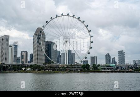 Singapore, 24 gennaio 2024: Singapore Flyer contro lo skyline della città. Iconico punto di riferimento che torreggia sul paesaggio urbano, catturando energia vibrante e moderna A. Foto Stock