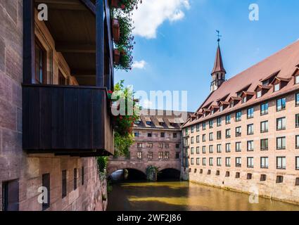L'Heilig-Geist-Spital di Norimberga, in Germania, ex ospedale costruito nel 1339 lungo il fiume Pegnitz, è ora un ristorante e una casa per anziani. Foto Stock