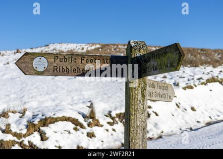 Un cartello di legno nelle Yorkshire Dales sulla strada Three Peaks in Inghilterra, che indica Ribblehead. Preso in una giornata invernale con molta neve. Foto Stock