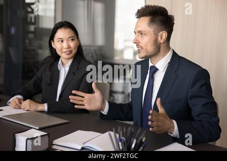 Uomo professionale impegnato e ispirato che offre idee per il brainstorming di squadra Foto Stock
