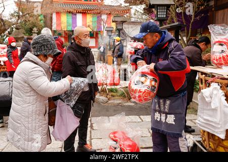 Tokyo, Giappone. 28 gennaio 2024. La gente compra le bambole Daruma al tempio Takahata Fudoson di Hino City, nei sobborghi occidentali di Tokyo. I visitatori si riuniscono per comprare le bambole Daruma (senza pupille dipinte sugli occhi), in cerca di fortuna durante l'anno. Le persone colorano in un allievo quando si fa un desiderio, o si stabilisce un obiettivo, e quando il desiderio si avvera, o l'obiettivo viene raggiunto, riempiono l'altro allievo. Alla fine dell'anno, le bambole Daruma usate vengono restituite al tempio per essere bruciate. Crediti: ZUMA Press, Inc./Alamy Live News Foto Stock