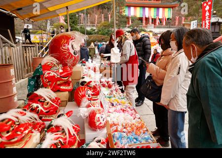 Tokyo, Giappone. 28 gennaio 2024. La gente compra le bambole Daruma al tempio Takahata Fudoson di Hino City, nei sobborghi occidentali di Tokyo. I visitatori si riuniscono per comprare le bambole Daruma (senza pupille dipinte sugli occhi), in cerca di fortuna durante l'anno. Le persone colorano in un allievo quando si fa un desiderio, o si stabilisce un obiettivo, e quando il desiderio si avvera, o l'obiettivo viene raggiunto, riempiono l'altro allievo. Alla fine dell'anno, le bambole Daruma usate vengono restituite al tempio per essere bruciate. Crediti: ZUMA Press, Inc./Alamy Live News Foto Stock