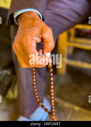 Primo piano della mano che tiene perline di preghiera. Foto Stock