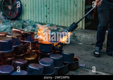 Le pentole e i bollitori in rame N4w sono temperati termicamente utilizzando una torcia a propano per le strade della Turchia. Foto Stock