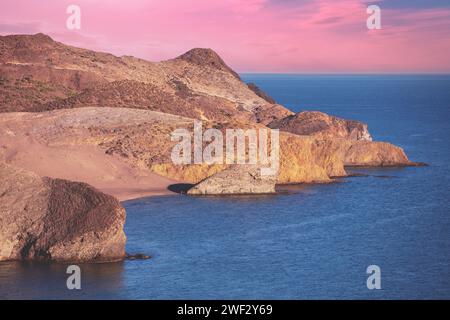 Costa rocciosa al tramonto. Vista sul mare di sera. Riserva naturale Cabo de Gata Nijar. Almeria, Andalusia, Spagna Foto Stock