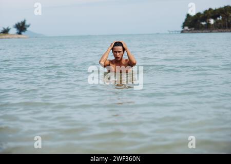 Nuotatore nelle acque tropicali che abbraccia la beatitudine delle vacanze estive Foto Stock