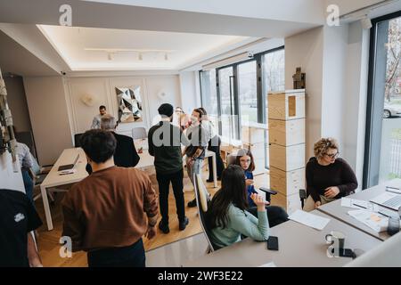 Team diversificato di colleghi che collaborano in uno spazio ufficio luminoso e moderno. Foto Stock