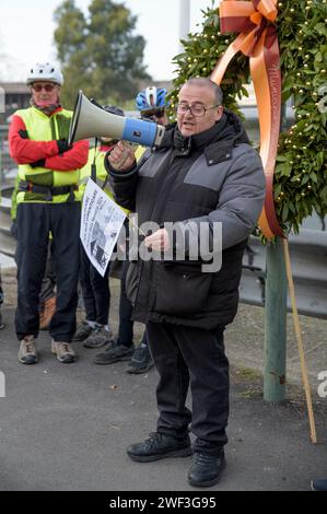 Roma, Italia. 28 gennaio 2024. ANDREA DI VEROLI, presidente dell'Associazione Nazionale ex deportati nei campi nazisti (ANED), parla del megafono con una bandiera con il disegno dei deportati nei campi di sterminio in occasione della pedalata in memoria di Settimia Spizzichino a Roma. Alcuni ciclisti hanno dato vita alla solita pedalata in memoria di Settimia Spizzichino, l'unica donna, tra le tante deportate dal Ghetto ebraico di Roma, sopravvissuta al campo di sterminio di Auschwitz, in occasione delle commemorazioni per la giornata della memoria per le vittime dell'Olocausto. Gli Ostiens Foto Stock