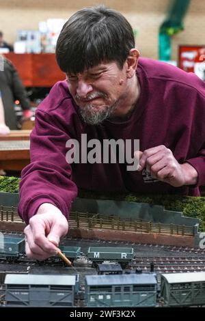 Kendal, Cumbria 28 gennaio 2024 - un espositore si aggiudica i treni. - Gli appassionati di treni giovani e vecchi apprezzano le mostre di modellini ferroviari al Kendal Leisure Centre in Cumbria. Recentemente la Warley National Model Railway Exhibition di Birmingham ha annullato il loro spettacolo annuale a causa di un'adesione "anziana" i bambini di Kendal erano tutti affascinati dalle mostre mentre i treni giravano intorno al tracciato. Credito: Stop Press Media/Alamy Live News Foto Stock