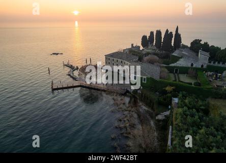 Punta San Vigilio - Vista aerea con droni in una giornata invernale di foschia al tramonto, luogo romantico del Lago di Garda chiamato Portofino del Lago di Garda. Northern Ital Foto Stock