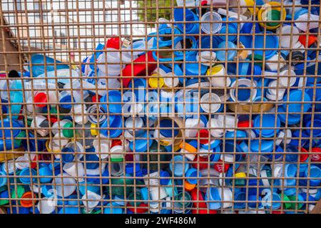 Ampia selezione di bottiglie di plastica colorata in una zona a gabbia a forma di cuore. Foto Stock