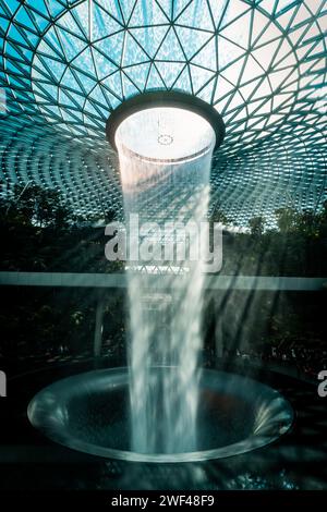 Architectural Marvel: Il vortice della pioggia all'aeroporto Jewel Changi, una fusione di natura e design moderno Foto Stock