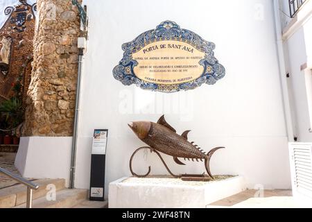 Targa municipale di piastrelle e statua del pesce che colloca l'ingresso al castello di Albufeira in Portogallo, 24 gennaio 2024 Foto Stock