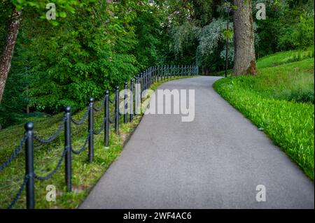 Un sentiero pedonale conduce attraverso il parco. Smiltene Old Park, Lettonia. Foto Stock