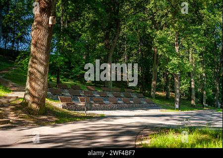 Panchine di legno nel teatro estivo sulla strada. Palco aperto per uno spettacolo nel parco. Smiltene Old Park, Lettonia. Foto Stock