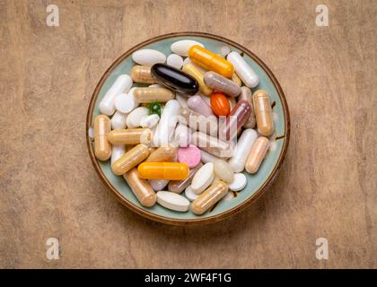 colazione per un integratore drogato - pillole vitaminiche, capsule e compresse in una piccola ciotola - stile di vita sano, overdose o concetto di dipendenza Foto Stock