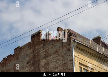 la gente ha restaurato il tetto di una vecchia casa in città Foto Stock