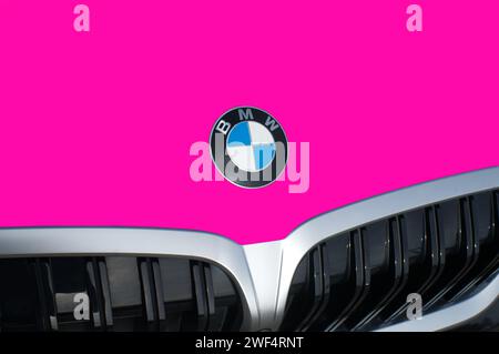 OCALA, FLORIDA - 2 NOVEMBRE 2023 emblema del logo BMW sul cofano auto rosa intenso. Bavaria Motor Works multinazionale tedesca produttrice di veicoli di lusso Foto Stock