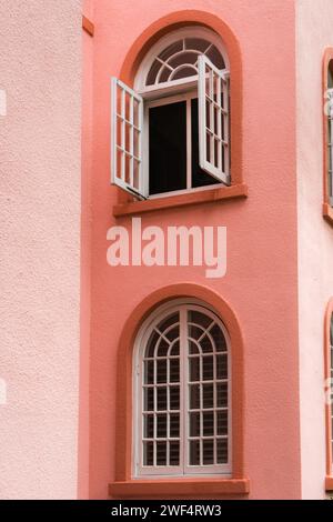 Edificio d'epoca color pesca con esterni con finestre e porte ad arco nel colore del pesco fuzz. Foto Stock