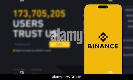 Istanbul, Turchia - 25 gennaio 2024: Logo del marchio Binance sullo schermo dello smartphone con il sito Web Binance sullo sfondo. Binance è una criptovaluta globale ecc Foto Stock