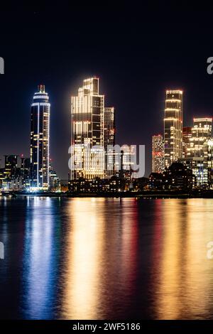 Vauxhall notturna a lunga esposizione, skyline di Londra che si riflette nel fiume. I luoghi di interesse includono l'ambasciata degli Stati Uniti, One Nine Elms e la St George Tower. Foto Stock