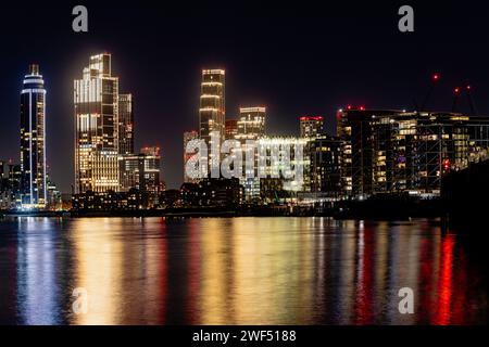 Vauxhall notturna a lunga esposizione, skyline di Londra che si riflette nel fiume. I luoghi di interesse includono l'ambasciata degli Stati Uniti, One Nine Elms e la St George Tower. Foto Stock