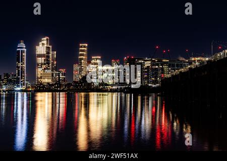 Vauxhall notturna a lunga esposizione, skyline di Londra che si riflette nel fiume. I luoghi di interesse includono l'ambasciata degli Stati Uniti, One Nine Elms e la St George Tower. Foto Stock