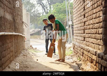 Due ragazzi che camminano lungo una strada stretta tenendo in mano lo skateboard Foto Stock