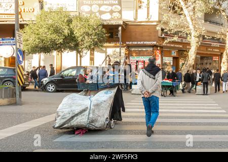 Rifugiati del Medio Oriente - una madre e i bambini che usano un carrello con una borsa mentre camminano attraverso la città di Sanliurfa in Turchia Foto Stock