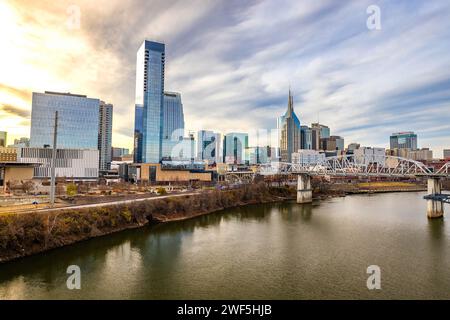 Nashville, TN, USA - 24-12-2023: Vista panoramica dello skyline del centro di Nashville e del fiume Cumberland al tramonto Foto Stock