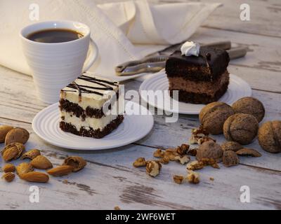 Un primo piano di due pezzi di torte con una tazza di caffè su un tavolo di legno Foto Stock