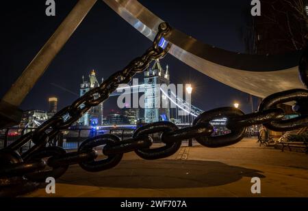 Londra. UK-01.27.2024. Una vista notturna del Tower Bridge da sotto la scultura dell'orologio Sundial. Foto Stock