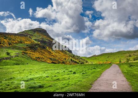 Paesaggio con Arthur's Seat a Holyrood Park e sentiero attraverso prati in primavera, Edimburgo, Scozia, Regno Unito. Foto Stock