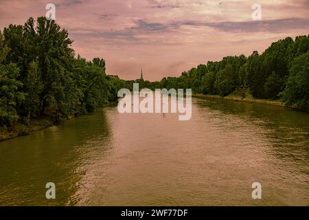 Una tranquilla vista del po che scorre attraverso Torino, Italia, sotto un cielo dipinto di colori del tramonto. Foto Stock