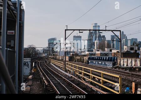 Skyline della città di Londra - vista dalla stazione DLR di Shadwell. Binario/viadotto del treno DLR e C2C in primo piano Foto Stock