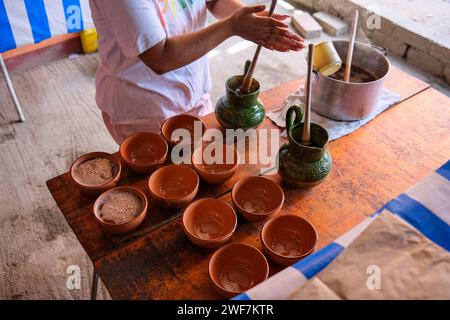 Donna a Oaxaca, Messico, che versa la tradizionale cioccolata calda di Oaxacan, Xocóatl Foto Stock