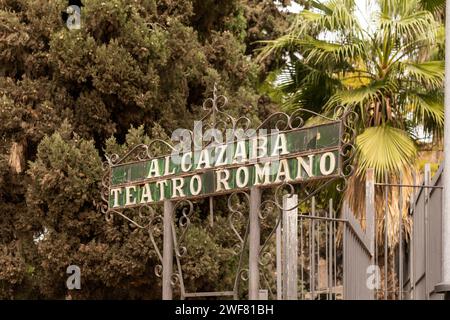 Malaga, Spagna- 26-01-2024: Insegna in metallo d'epoca "ALCAZABA TEATRO ROMANO" tra alberi lussureggianti. Il Teatro Romano è il monumento più antico della città di Malaga. Foto Stock