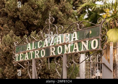 Malaga, Spagna- 26-01-2024: Insegna in metallo d'epoca "ALCAZABA TEATRO ROMANO" tra alberi lussureggianti. Il Teatro Romano è il monumento più antico della città di Malaga. Foto Stock