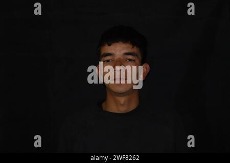 Foto di un ragazzo indiano adulto in inverno, foto di un ragazzo himalayano con vestito nero Foto Stock