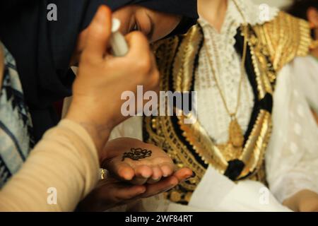 Tatuatrice all'henné che prepara la sposa araba per il suo matrimonio Foto Stock