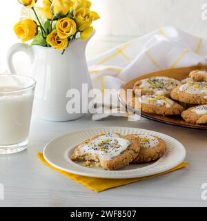 Un piatto di biscotti al limone con uno spuntino, serviti con latte. Foto Stock