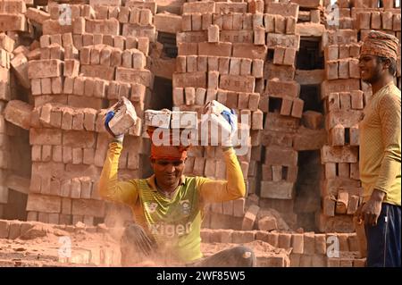 Dhaka, Dhaka, Bangladesh. 27 gennaio 2024. 28 gennaio 2024-Dacca, Bangladesh - Ritratto di un lavoro in muratura. Il mondo sta attraversando una rapida urbanizzazione e il Bangladesh non fa eccezione. Una tale rapida urbanizzazione genera una domanda massiccia di mattoni in quanto è uno degli ingredienti chiave per costruire strutture in cemento. Per rispondere a questa crescente esigenza, il numero di giacimenti di mattoni è aumentato a un ritmo allarmante in Bangladesh. La maggior parte di essi si svolgeva in terreni agricoli che causavano una riduzione della produzione agricola. Sappiamo che la combustione del carbone causa enormi emissioni di carbone Foto Stock