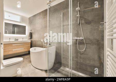 Bagno elegante e contemporaneo con cabina doccia, lavello a parete e design minimalista. Foto Stock