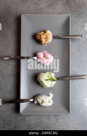 Vista dall'alto di quattro cucchiai con vari gusti di gelato. Visualizzazione soft Foto Stock