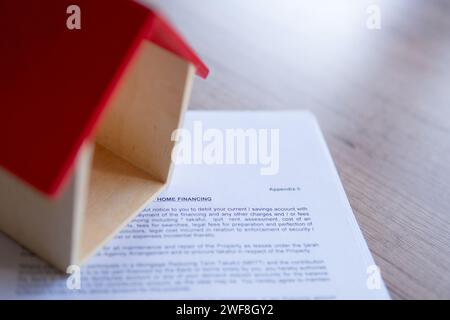 Immagine ravvicinata della casa dei giocattoli e della lettera di offerta di finanziamento per la casa dalla banca. Concetto di proprietà domestica. Foto Stock