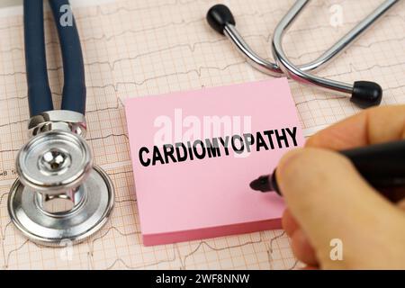 Concetto medico. Sugli elettrocardiogrammi è presente uno stetoscopio e un adesivo con la scritta cardiomiopatia Foto Stock