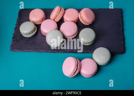 Primo piano del colorato dessert macaron con tonalità pastello d'epoca su tavola nera. . Foto Stock