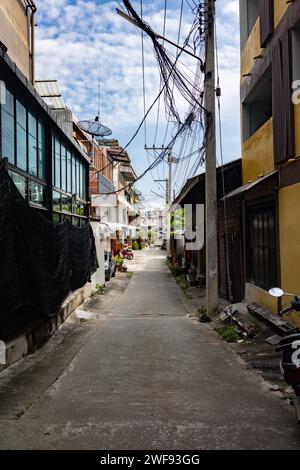 Un vicolo stretto con una motocicletta parcheggiata lateralmente, che crea una scena urbana visivamente interessante. Foto Stock